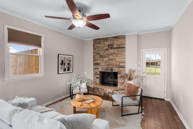 living room featuring light hardwood / wood-style floors, a stone fireplace, ceiling fan, and crown molding