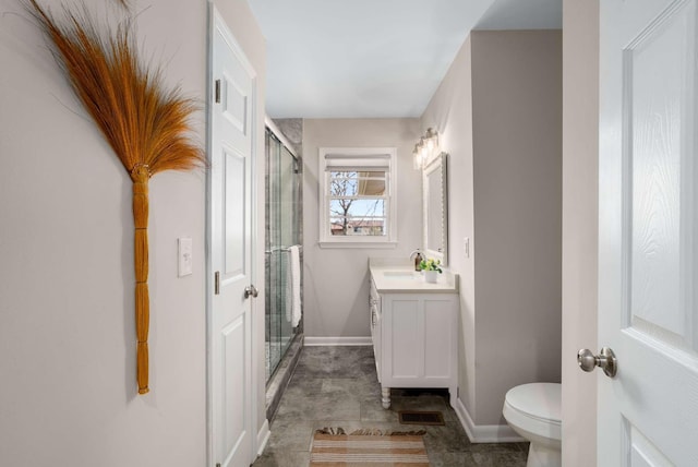 bathroom with vanity, toilet, and a shower with door