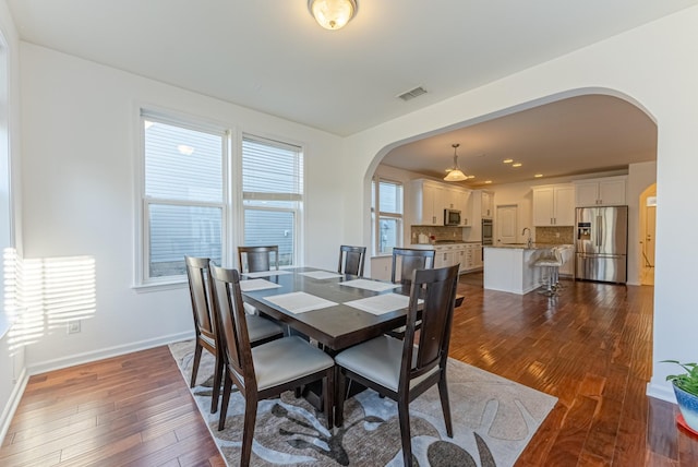 dining area with dark hardwood / wood-style floors and sink