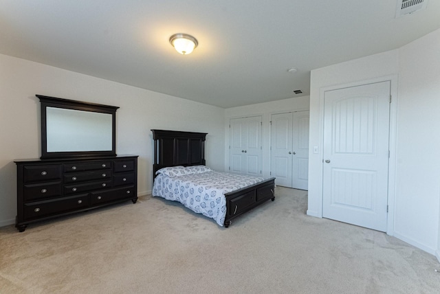 carpeted bedroom featuring two closets