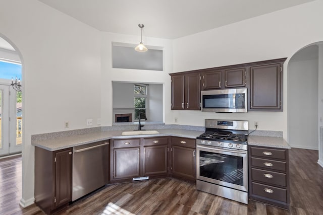 kitchen with a healthy amount of sunlight, sink, stainless steel appliances, and decorative light fixtures