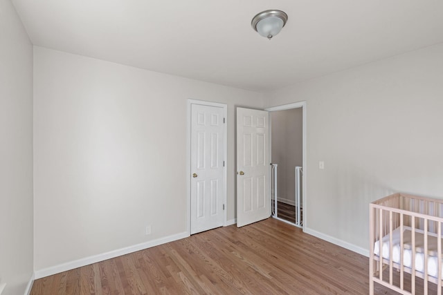 unfurnished bedroom with light wood-type flooring and a closet