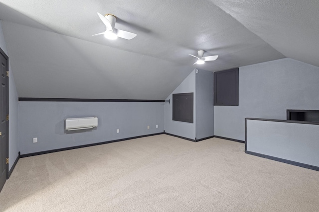 additional living space with light carpet, vaulted ceiling, ceiling fan, a textured ceiling, and a wall unit AC