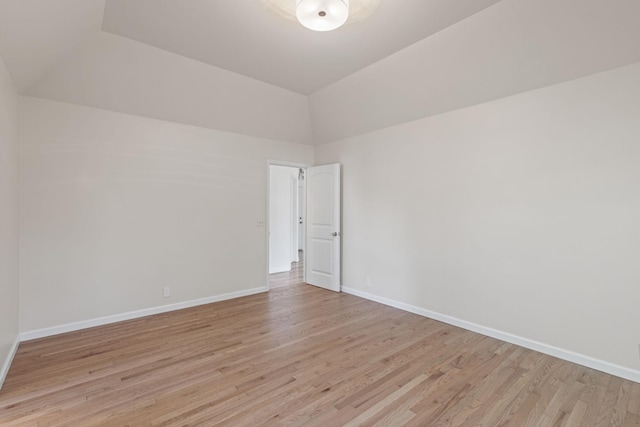 unfurnished room featuring lofted ceiling and light wood-type flooring