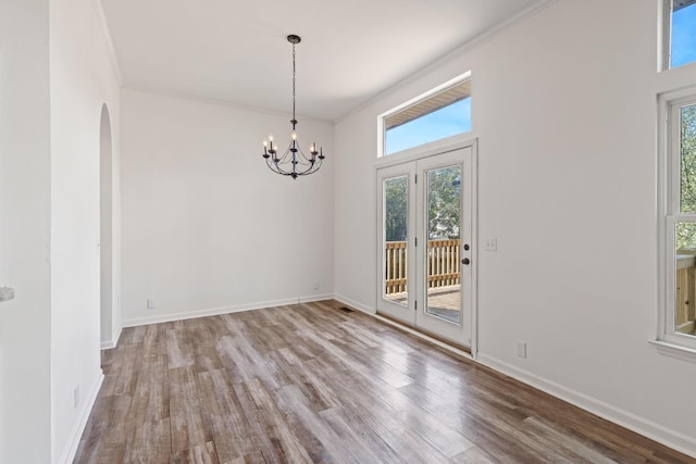 unfurnished room with wood-type flooring and a notable chandelier