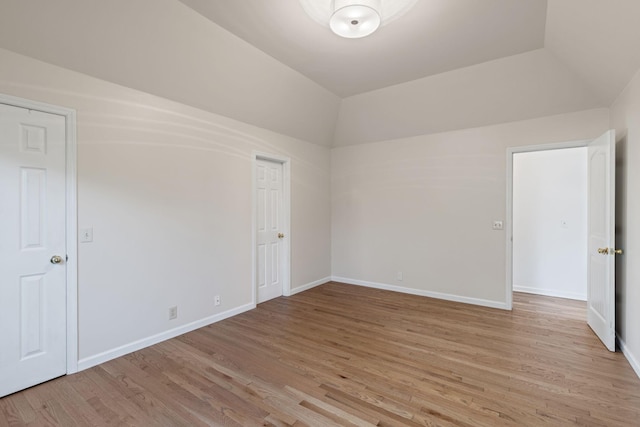 interior space with light wood-type flooring and vaulted ceiling