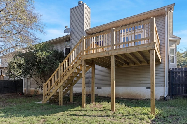 back of property with a deck and a yard