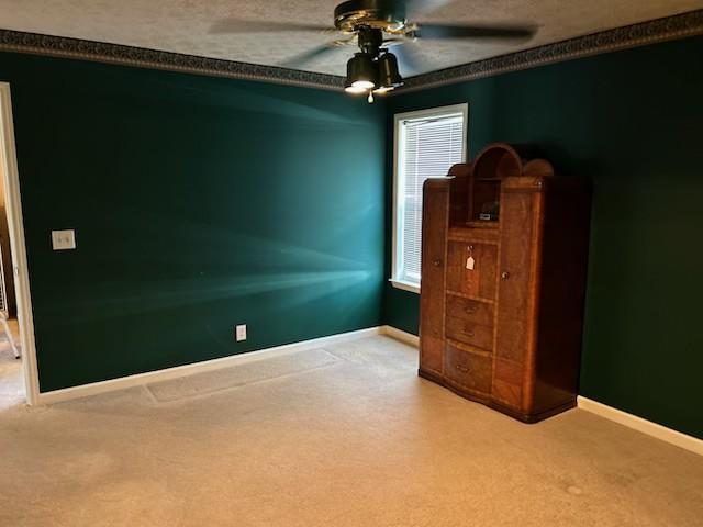 interior space featuring a textured ceiling, ceiling fan, and ornamental molding