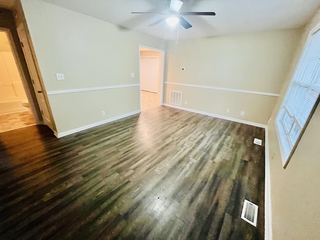 spare room with ceiling fan and dark wood-type flooring