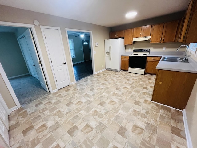 kitchen featuring white appliances, sink, and light carpet