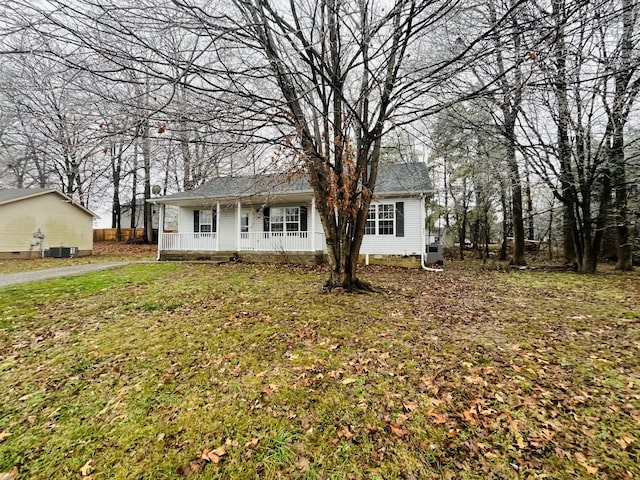 view of front of house featuring a front lawn, covered porch, and central AC