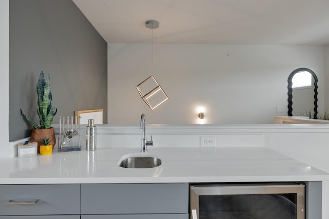 kitchen featuring gray cabinetry, pendant lighting, sink, and wine cooler