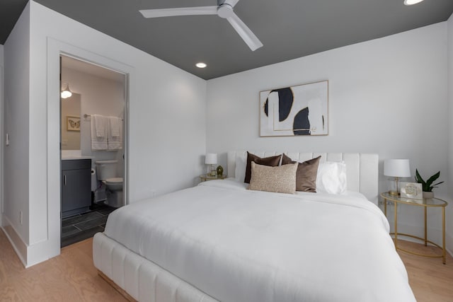 bedroom with ensuite bathroom, ceiling fan, and light hardwood / wood-style floors