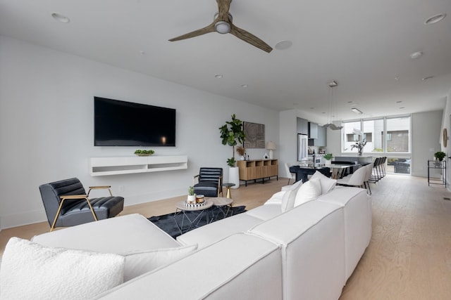 living room with light wood-type flooring and ceiling fan