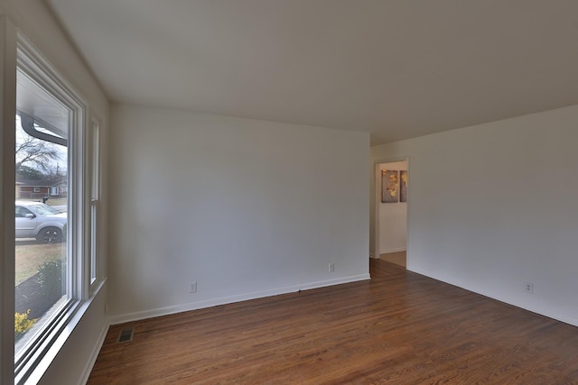 unfurnished room with dark hardwood / wood-style flooring