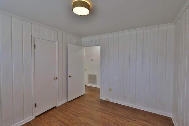 unfurnished bedroom featuring hardwood / wood-style flooring and ornamental molding