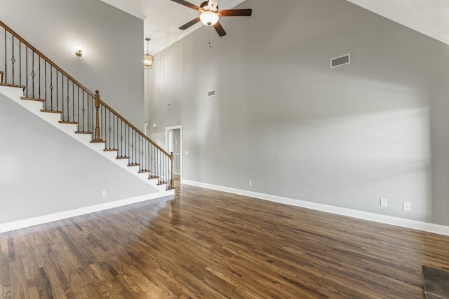 unfurnished living room featuring a high ceiling, dark hardwood / wood-style flooring, and ceiling fan