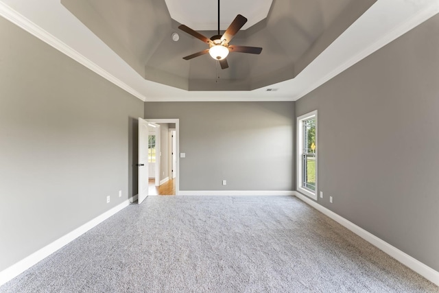 spare room featuring ceiling fan, a raised ceiling, light carpet, and crown molding