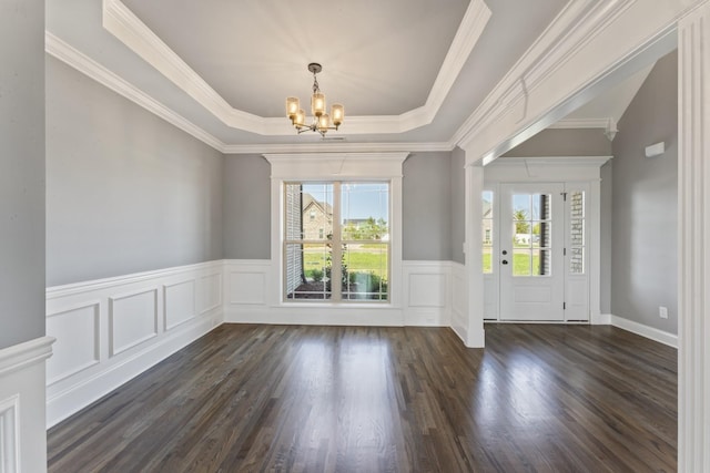 foyer entrance with a chandelier, a healthy amount of sunlight, ornamental molding, and a tray ceiling