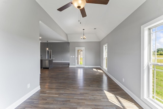 empty room featuring ceiling fan with notable chandelier, dark wood-type flooring, and lofted ceiling