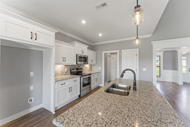 kitchen featuring pendant lighting, white cabinets, sink, light stone counters, and stainless steel appliances