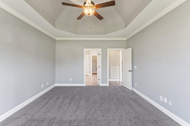 unfurnished bedroom with carpet, ceiling fan, a raised ceiling, and ornamental molding