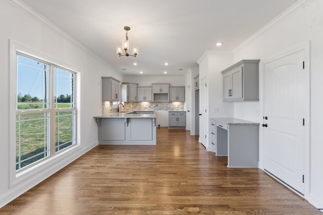 kitchen featuring kitchen peninsula, decorative backsplash, dark hardwood / wood-style flooring, and gray cabinetry