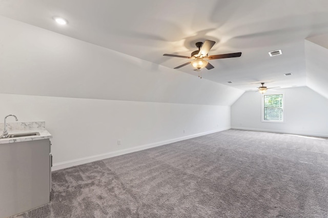 additional living space featuring ceiling fan, sink, dark carpet, and lofted ceiling