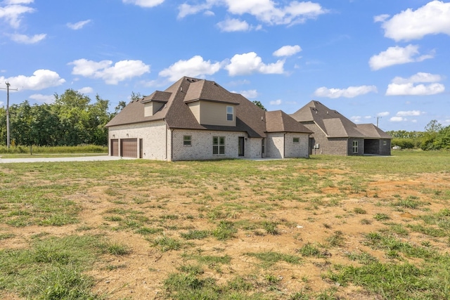 back of property with a yard and a garage