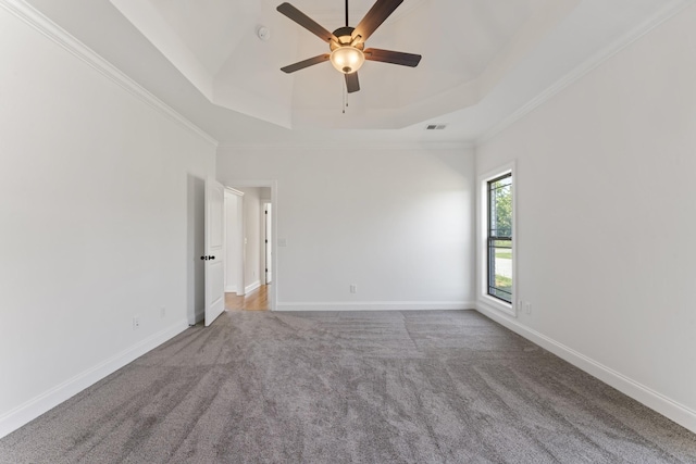 spare room with carpet flooring, a raised ceiling, ceiling fan, and ornamental molding