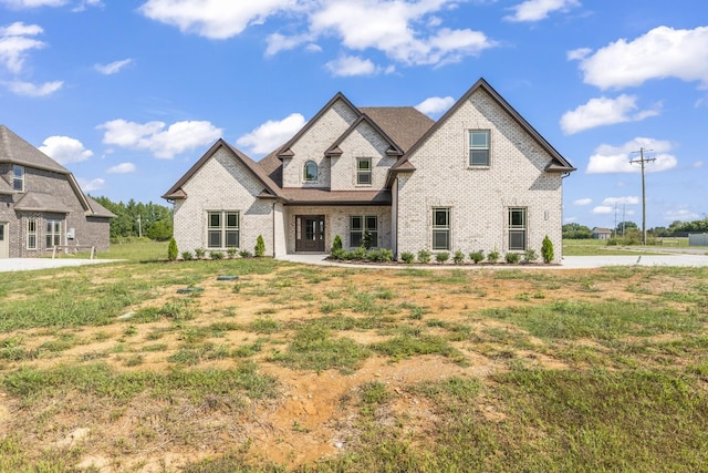 french country inspired facade with a front yard