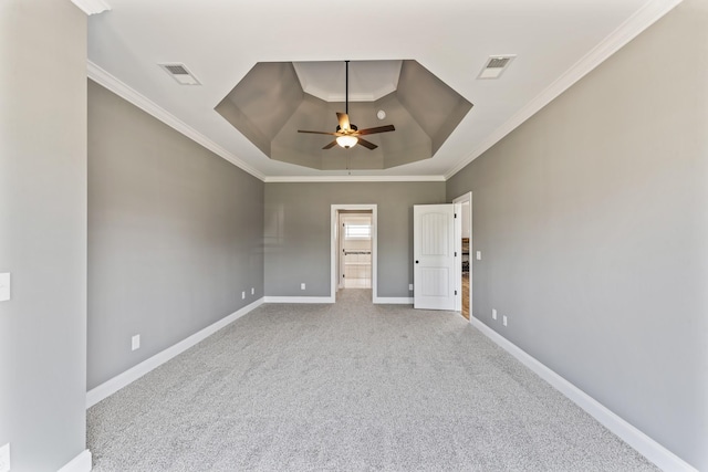 carpeted empty room with a raised ceiling, ceiling fan, and crown molding