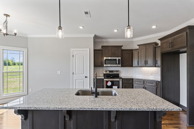 kitchen with sink, hanging light fixtures, tasteful backsplash, light stone counters, and stainless steel appliances