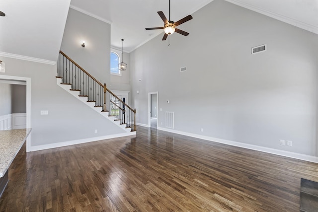 unfurnished living room featuring ceiling fan with notable chandelier, dark hardwood / wood-style floors, a towering ceiling, and crown molding