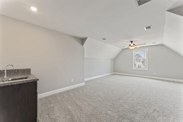 additional living space with ceiling fan, sink, light colored carpet, and lofted ceiling