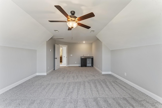 additional living space featuring light colored carpet, vaulted ceiling, and ceiling fan