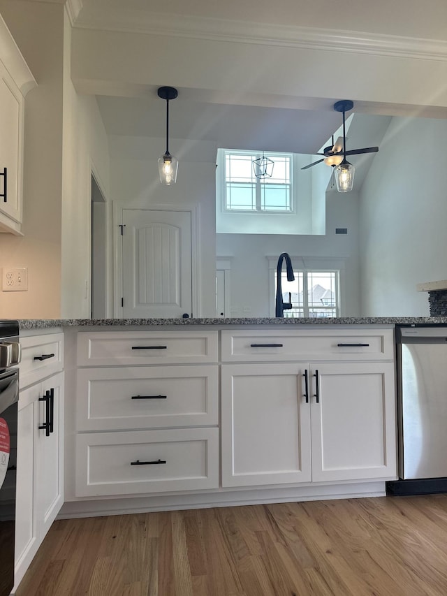 kitchen with light stone countertops, white cabinetry, light hardwood / wood-style flooring, and stainless steel dishwasher