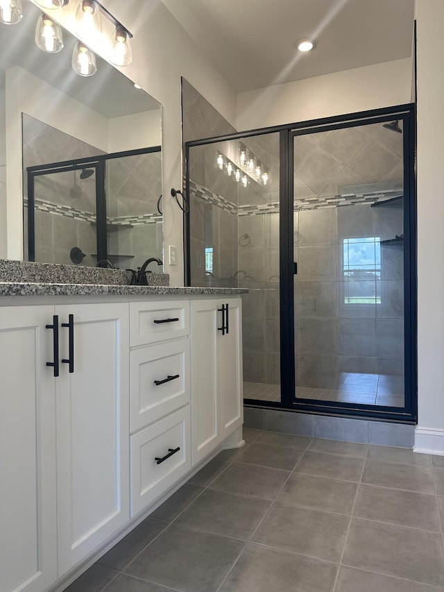 bathroom with tile patterned floors, vanity, and an enclosed shower