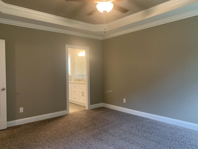 unfurnished bedroom with ensuite bath, ceiling fan, a raised ceiling, crown molding, and light carpet