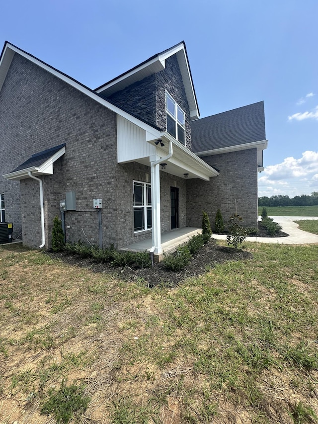 view of property exterior with a yard and a patio