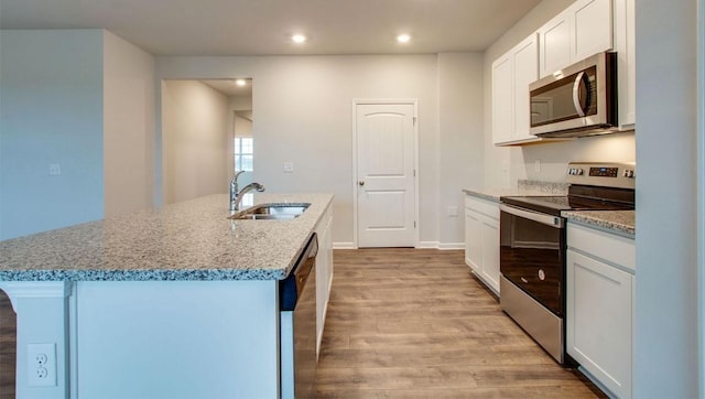 kitchen featuring white cabinetry, sink, a kitchen island with sink, and appliances with stainless steel finishes