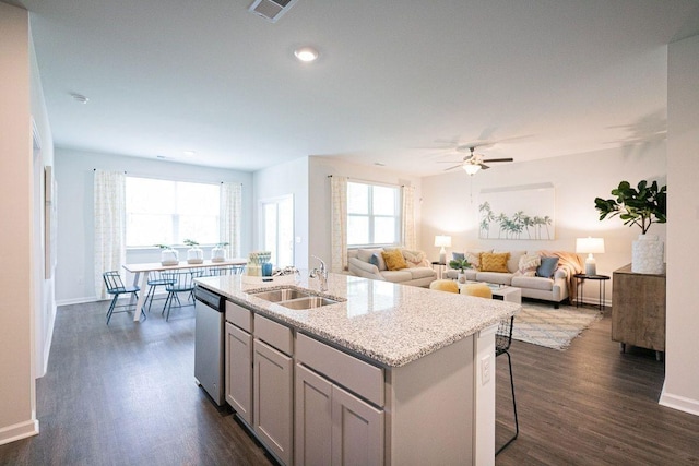 kitchen with ceiling fan, dishwasher, sink, dark hardwood / wood-style flooring, and a kitchen island with sink