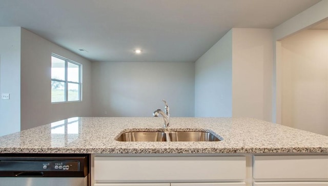 kitchen with dishwasher, light stone countertops, white cabinetry, and sink