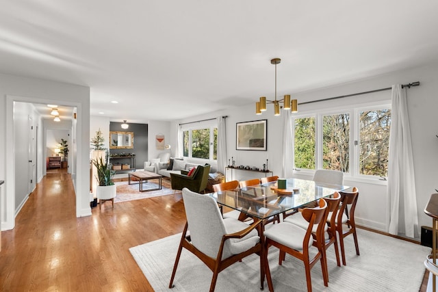 dining space featuring light wood-type flooring and a notable chandelier