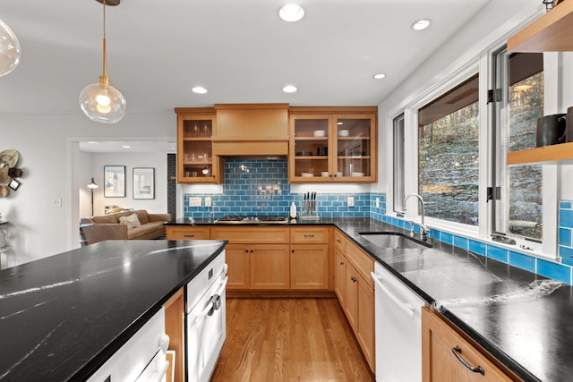 kitchen with white dishwasher, sink, pendant lighting, light hardwood / wood-style flooring, and stainless steel gas stovetop