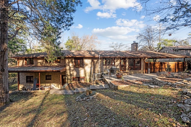 rear view of property featuring a patio area and a lawn