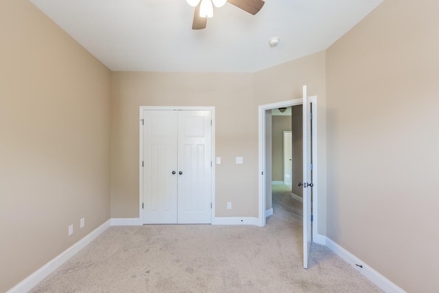 unfurnished bedroom featuring light carpet, a closet, and ceiling fan