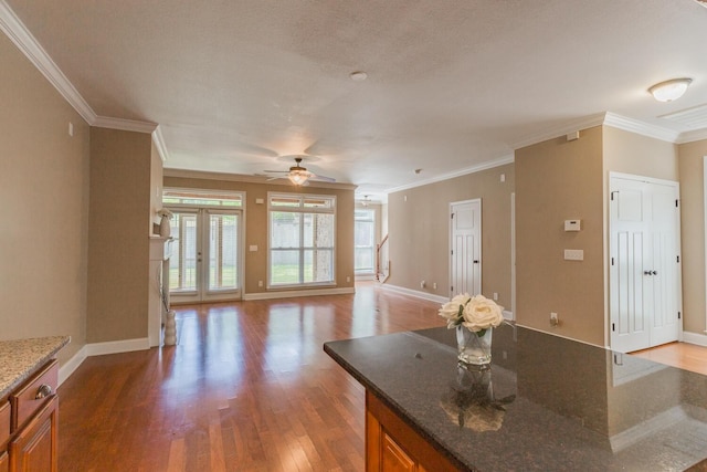 kitchen with hardwood / wood-style floors, dark stone counters, french doors, ceiling fan, and ornamental molding