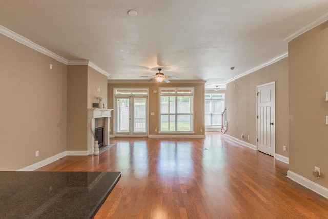 unfurnished living room with ceiling fan, hardwood / wood-style floors, and ornamental molding