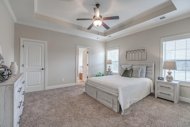 bedroom with connected bathroom, a tray ceiling, ceiling fan, and light colored carpet